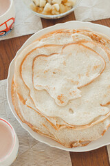 Pancake baking process. Ready-made pancakes on a white plate.