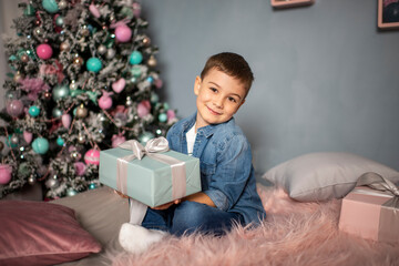 Obraz na płótnie Canvas Happy cheerful boy with a new year's gift