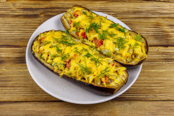 Baked stuffed eggplants on a wooden table. Healthy food and dieting concept