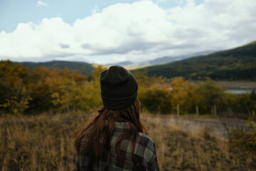 woman tourist in autumn on nature in the mountains back view