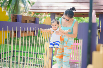 Obraz premium Asian Baby boy playing in sandbox with his monther,Healthy active baby outdoors plays toy