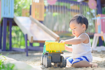 Asian Baby boy playing with sand in a sandbox,Healthy active baby outdoors plays toy