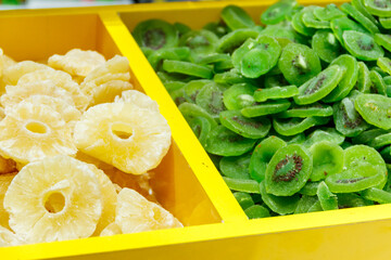 Candied fruit pieces of kiwi and pineapple for sale in a market