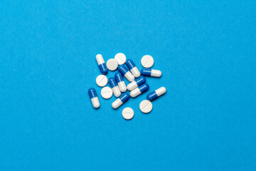 Fototapeta na wymiar group of pills or capsules on blue background