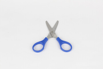 A blue used a scissor at the white background