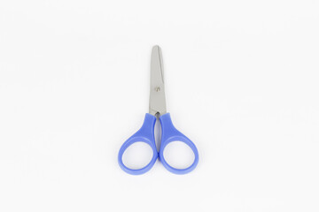 A blue used a scissor at the white background