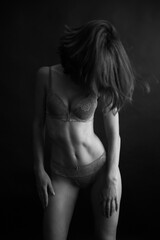 Obraz premium black and white portrait of a young girl on a dark background in the Studio