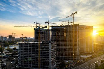 Construction site with cranes at sunset. Construction of an apartment building