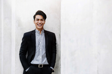 Portrait of Smiling Young Asian Businessman in Casual Suit. Standing in the City. Looking at Camera. a Happy Friendly Man