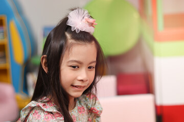 Portrait of smiling young beautiful girl at playground, kid having fun and playing with friend