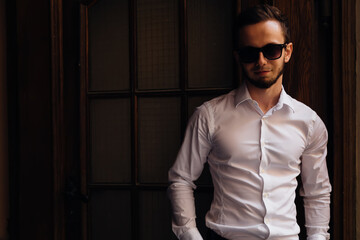 Trendy outfit. guy with cool hairstyle, in white shirt with sung