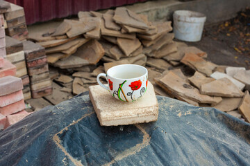 A bright mug with coffee stot on the ruins. Contrast.