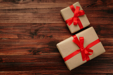Christmas and new year with gift boxes wrapped with kraft brown paper and red ribbon on wooden...