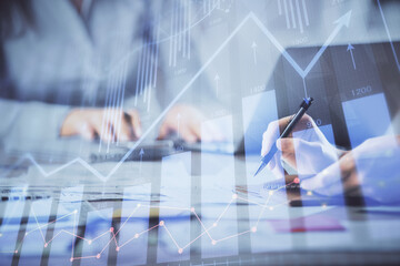 Multi exposure of woman hands typing on computer and forex chart hologram drawing. Stock market analysis concept.