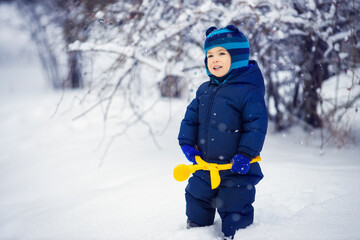 Fototapeta na wymiar little boy with toy for making snowballs