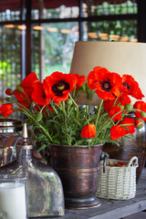 Still life with red poppies in a vase.
