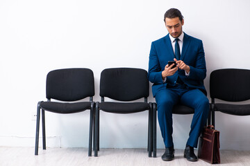 Young businessman waiting for an interview at hall