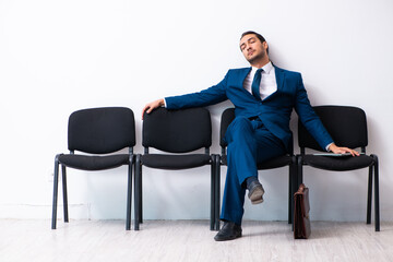 Young businessman waiting for an interview at hall
