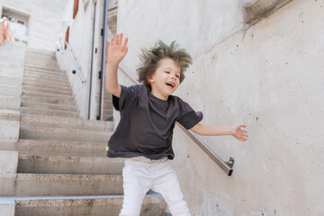 A cute boy is having fun jumping on the stairs. © Alexandr