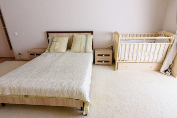 Bedroom interior, adult bed and newborn's bed nearby