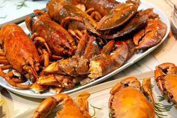 A lot of Lobster prawns and live mud crabs served grilled and steamed on the table.