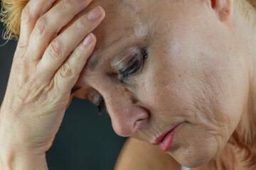 Portrait of a middle-aged white woman crying in pain and despair, with makeup running down her face