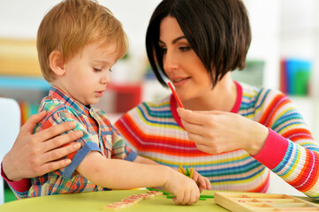 Obraz premium Young mother and cute little son playing