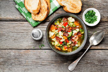 Soup with broccoli and cauliflower served with smoked bacon and toasted bread.