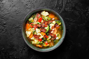 Soup with broccoli and cauliflower served with smoked bacon .Top view with space for text.