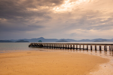 Naklejka premium Sunrise or sunset on the sea coast with pier near sea water