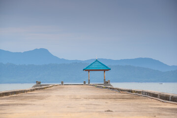 Sunrise or sunset on the sea coast with pier near sea water