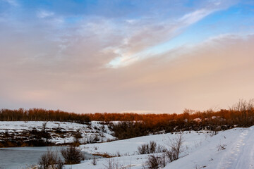 Spacious snow landscape. River and hills in Russia, white winter on the terrain, a lot of fluffy snow and ice under a beautiful blue sky. Rostov region, town of Shakhty, the river Grushevka