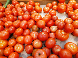 Red fresh tomatoes. A group of tomatoes. Lots of red tomatoes. Electoral focus. Food. Texture. Background. Vegetable storage, supermarket.