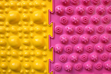 Two Orthopedic mats. Bright colorful multicolored mats to prevent flat feet and foot massage. View from above. Orthopedist. Prevention. Yellow and pink mat are joined together