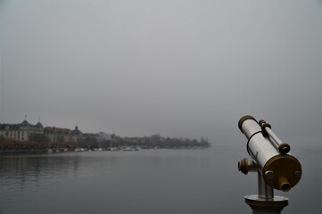 Fototapeta premium silver gold telescope on Lake Zurich on a cloudy, foggy day