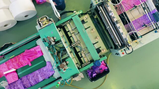 Top view of a factory conveyor with wrapping polyethylene bags in it