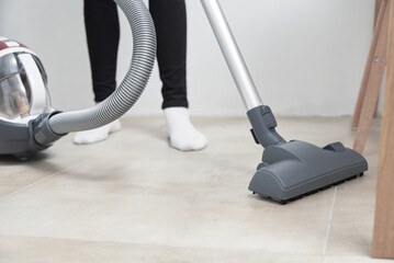 Woman use vacuum cleaner at the floor