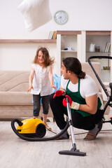 Young male contractor cleaning the house with his small daughter