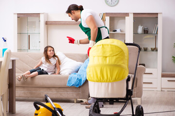 Young male contractor cleaning the house with his small daughter