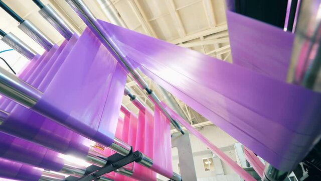 Coloured polyethylene is moving through the rolling conveyor