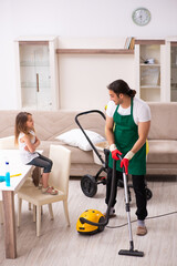 Young male contractor cleaning the house with his small daughter