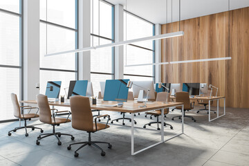 Open space office with leather chairs and computers on the table