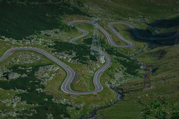 Detail of curves on epic winding road on Transfagarasan pass in Romania in summer time, with twisty road rising up. Road crossing Fagaras mountain range