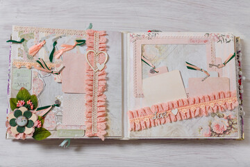Scrapbooking wedding photoalbum spread with blush paper decorative elements, flowers, beads, tapes, ribbons, hearts and frames for phographs.
