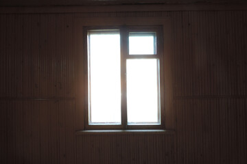 slightly blurry view of  dark empty room and light window , sunlight shining through window of  old country house, dark empty room