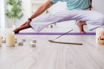 Obraz na płótnie Canvas Young man during yoga session at home