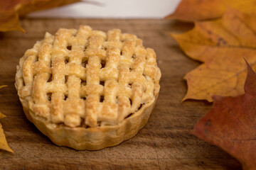 Autumn mini apple pie with lattice, ice cream, caramel sauce and leaves