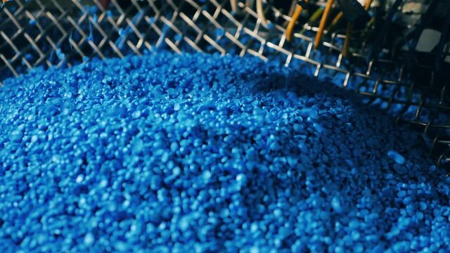 Pieces of high-pressure polyethylene are getting poured into a pile