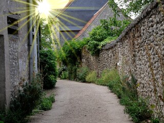 Weg in französischem Dorf mit Sonnenstrahlen