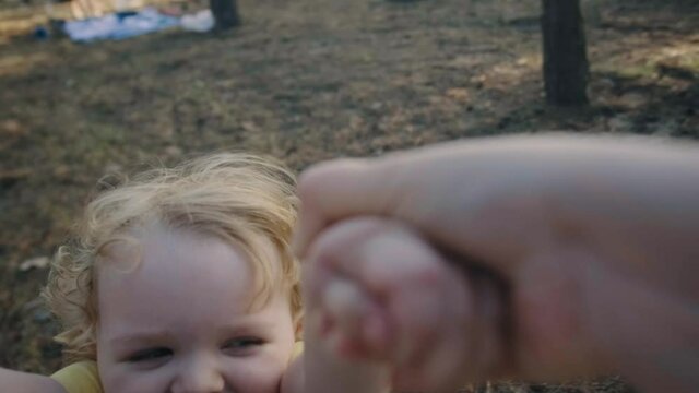Father holding spinning beautiful little son. Playing outside with loving parent. Happy childhood.